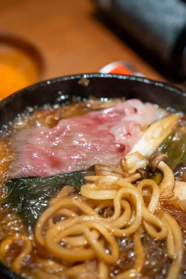 A sukiyaki pot with Wagyu, udon, tofu and vegetables
