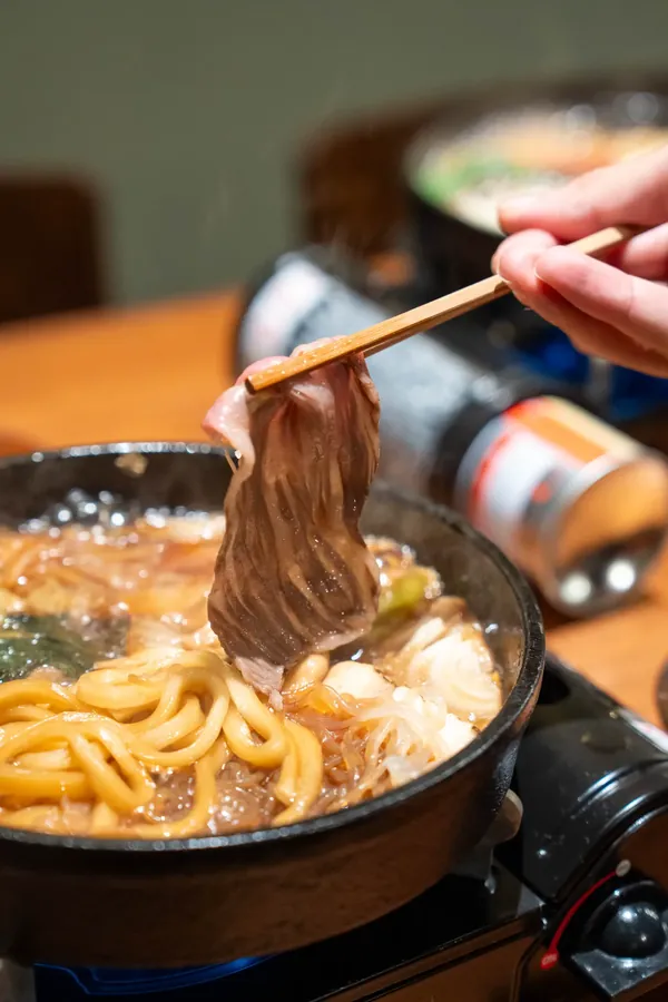 Glossy simmered Wagyu lifted from the sukiyaki pot