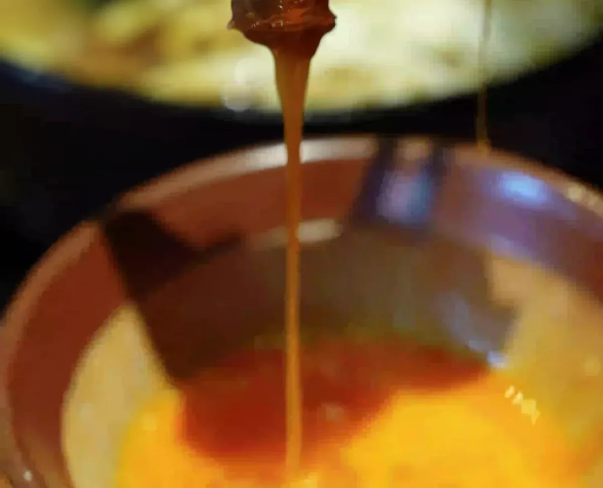 Golden beaten egg dripping from a slice of Wagyu into the bowl